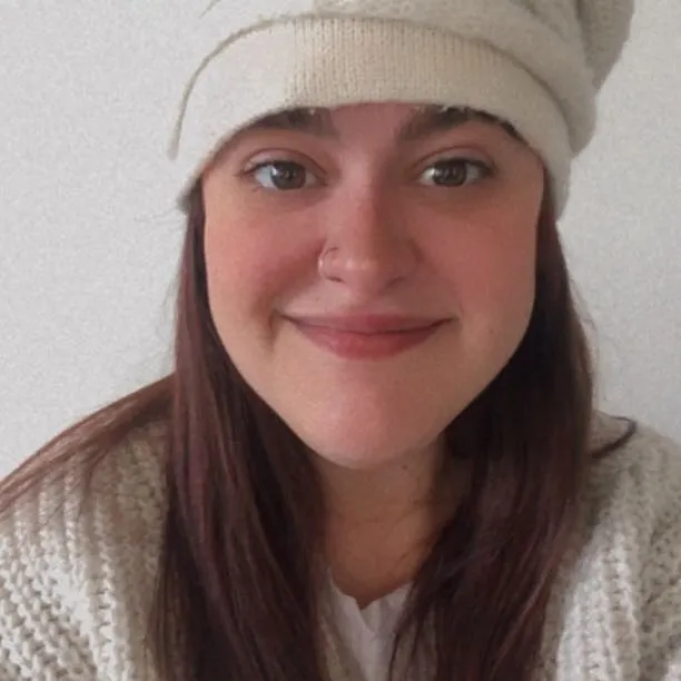 Samanta Ginefra sonriendo, con gorro de lana y sweater tejido color crema